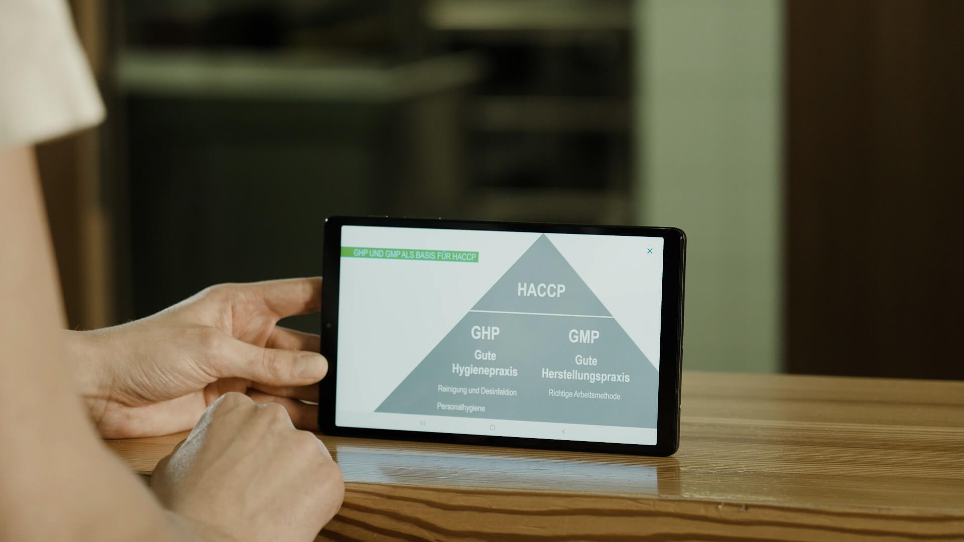 Küchenmitarbeiter lernt am Tablet über HACCP.
