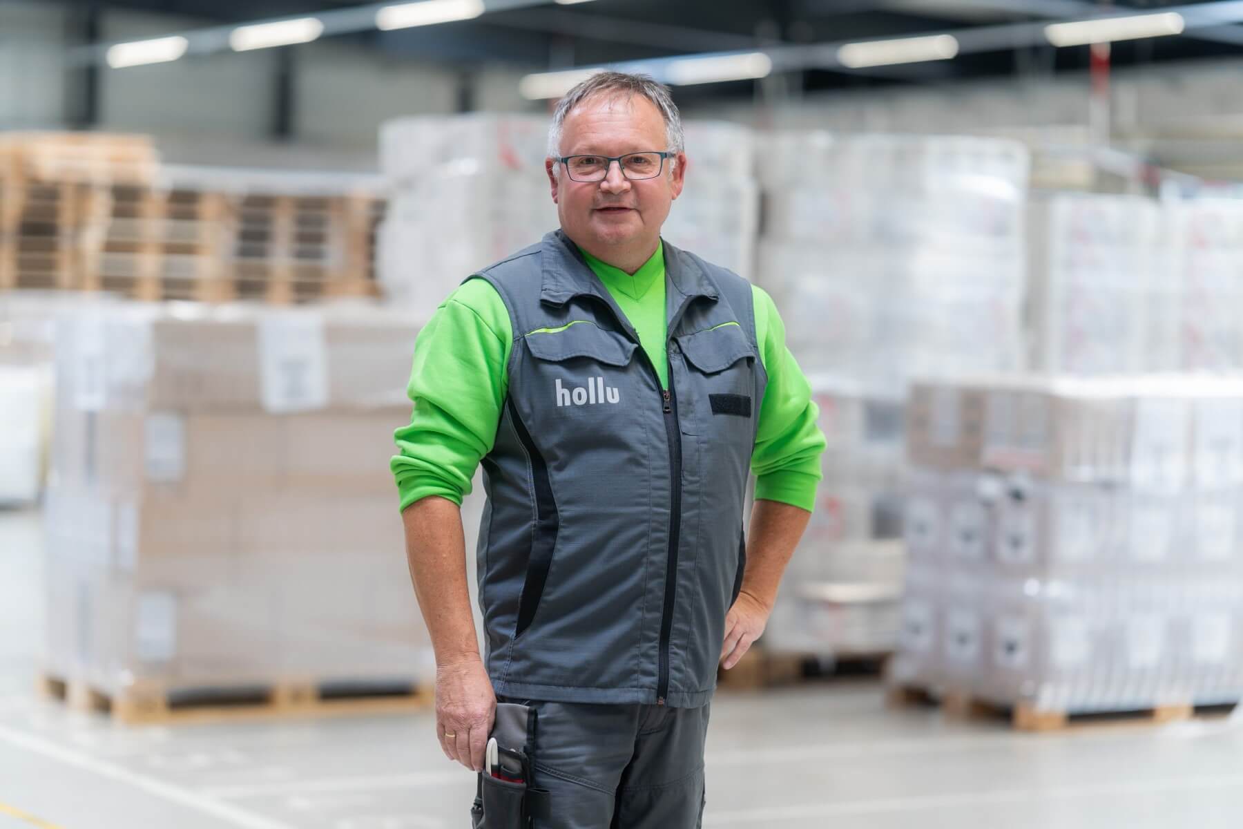 Ein Person in grün-grauer Arbeitskleidung